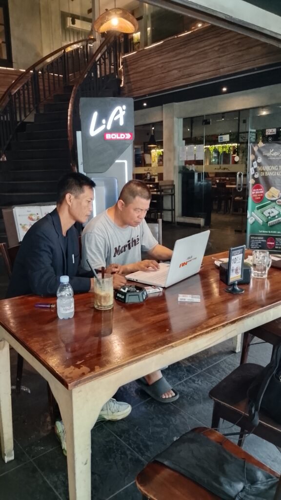 Coach Ton mendampingi peserta belajar digital marketing menggunakan laptop